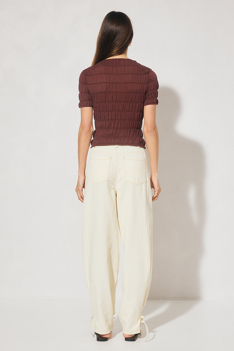 Skimming fit knitted tee shirt with round neckline, short sleeves, horizontal shirring detail, and narrow ribbed trims