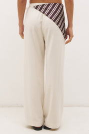 Woman wearing satin-backed linen blend wide leg pants with high-rise fit, scarf waist tie, elasticated back waistband, and relaxed tailored silhouette