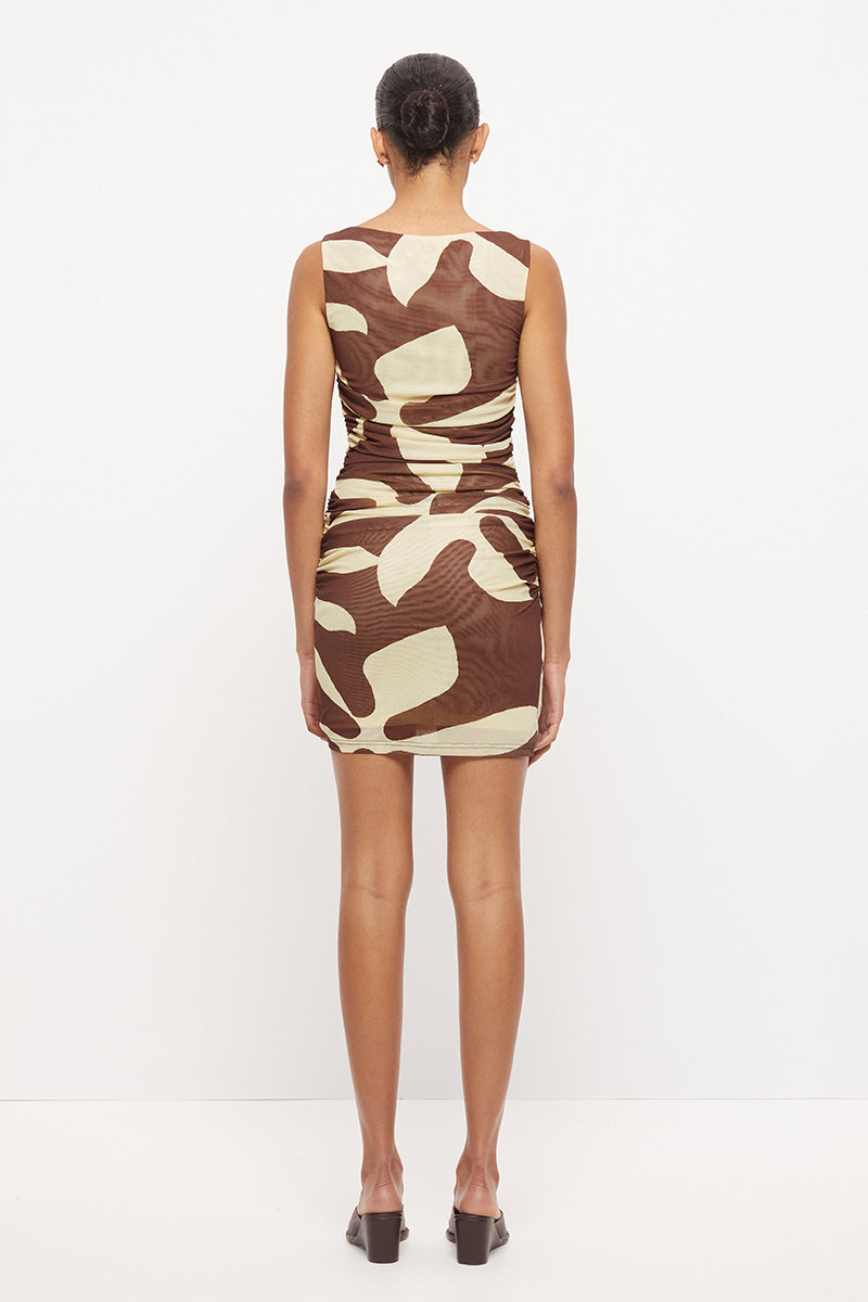 Sleeveless fitted mini dress with boat neckline, side ruching and sarong tie overlay in exclusive handcrafted print