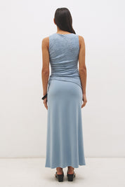 Woman wearing a sleeveless maxi dress with a textured lace bodice overlay, sunray ruching, boat neckline, and a contrast smooth A-line modal skirt in a fit-and-flare silhouette.