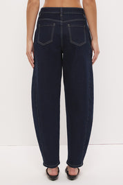 High-rise stretch denim barrel leg jeans with curved silhouette, contrast topstitching, and panelled construction