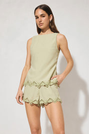 Sleeveless embroidered top with boat neckline, scooped back, functional waist tie, side splits, and relaxed fit