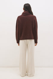 Woman wearing oversized scarf knit jumper with removable tassel scarf, crew neckline, ribbed trims, and relaxed silhouette