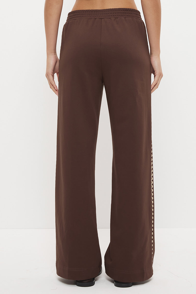 Woman wearing embroidered fleeced-back jersey sweatpants in a regular straight leg fit with contrast side seam embroidery and a topstitched elasticated waistband.