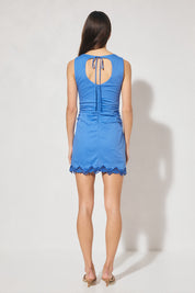 Sleeveless mini dress with scalloped embroidery, narrow boat neckline, gathered waist, and wide back cut-out with rouleau tie closure