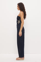 Strapless stretch denim top with straight neckline, contrast embroidery, bust darts, and exposed back zipper