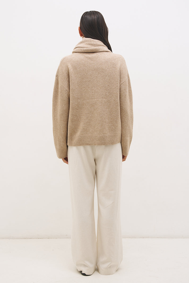 Woman wearing oversized scarf knit jumper with removable tassel scarf, crew neckline, ribbed trims, and relaxed silhouette