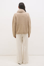 Woman wearing oversized scarf knit jumper with removable tassel scarf, crew neckline, ribbed trims, and relaxed silhouette