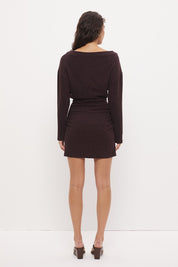 Oversized jersey mini dress with boat neckline, beaded asymmetrical waist straps, cinched silhouette, and fitted mini skirt