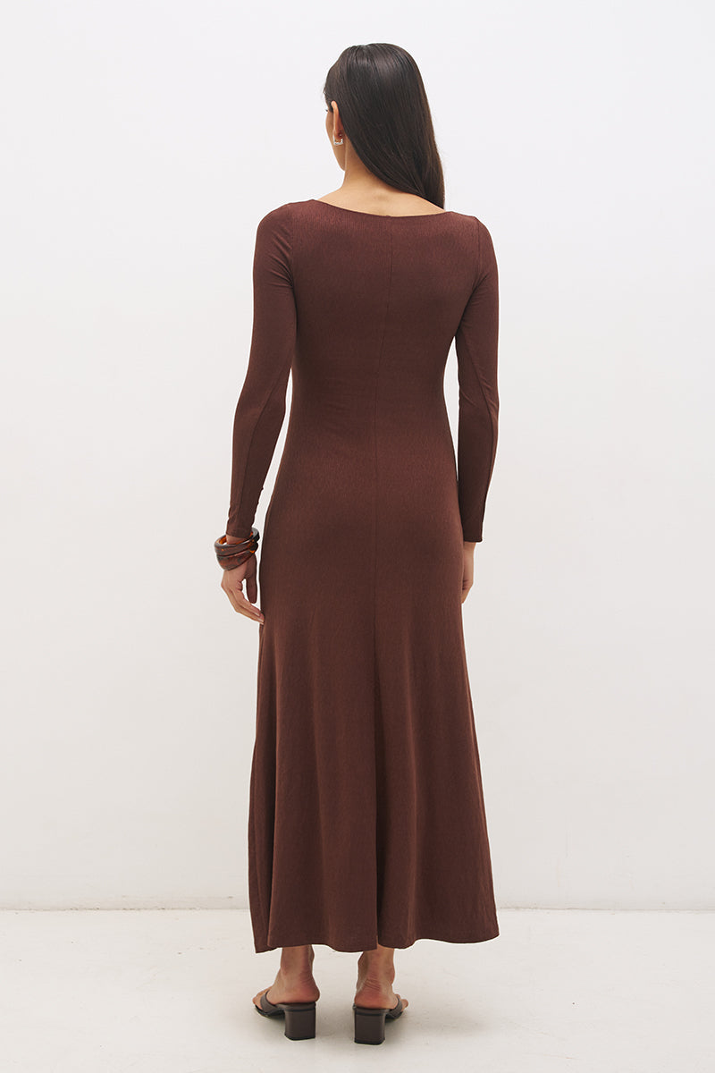 Woman wearing a textured cupro jersey long sleeve midi dress with boat neckline, cascading ruching, fit-and-flare silhouette, and draped A-line hem
