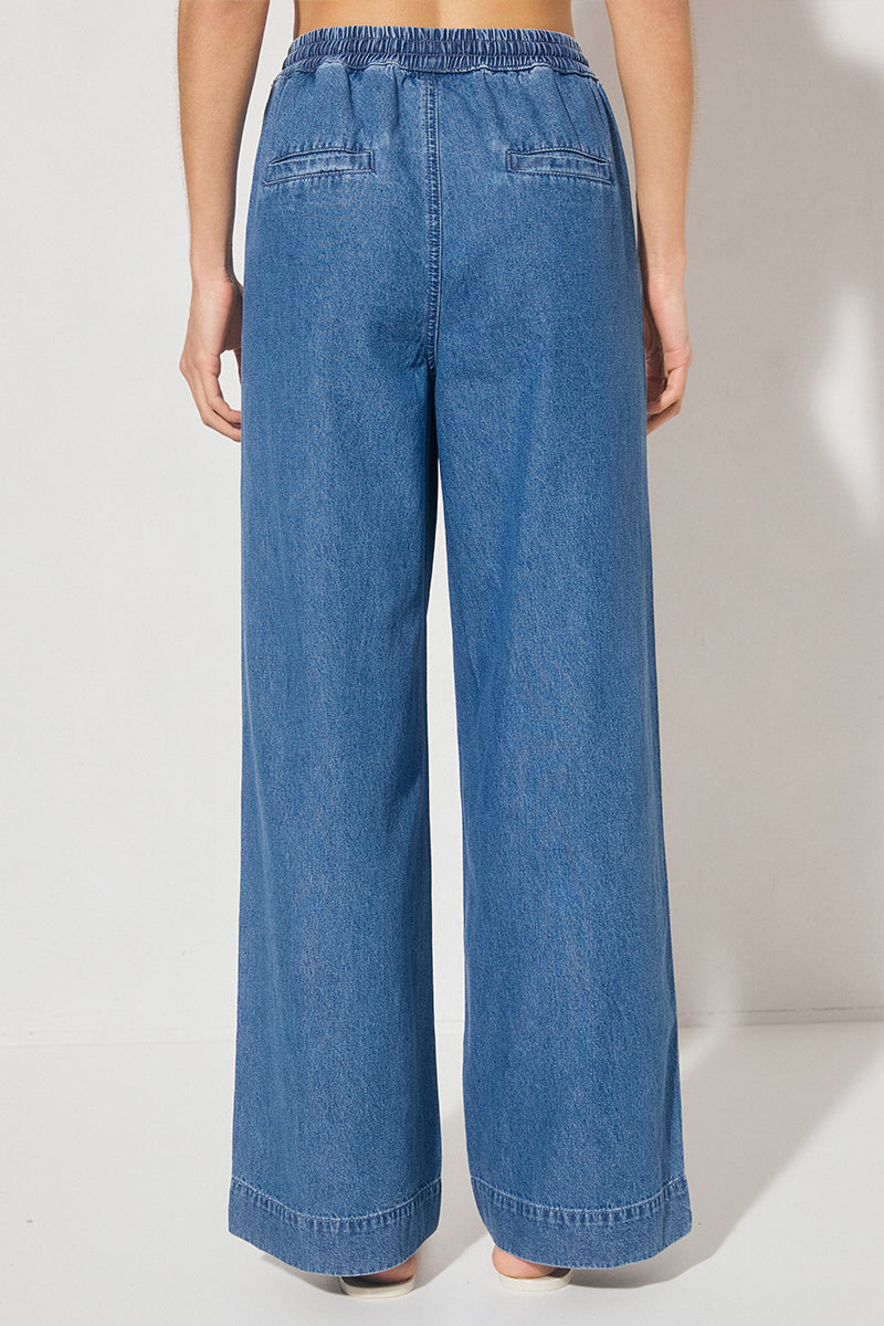 Wide-leg denim jeans with elastic waistband, cornelli piping, slant front pockets, back welt pockets, and heavy topstitching