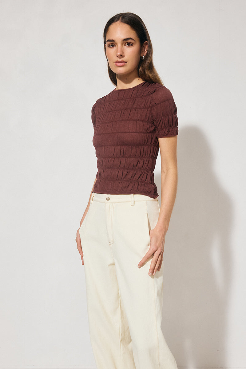 Skimming fit knitted tee shirt with round neckline, short sleeves, horizontal shirring detail, and narrow ribbed trims