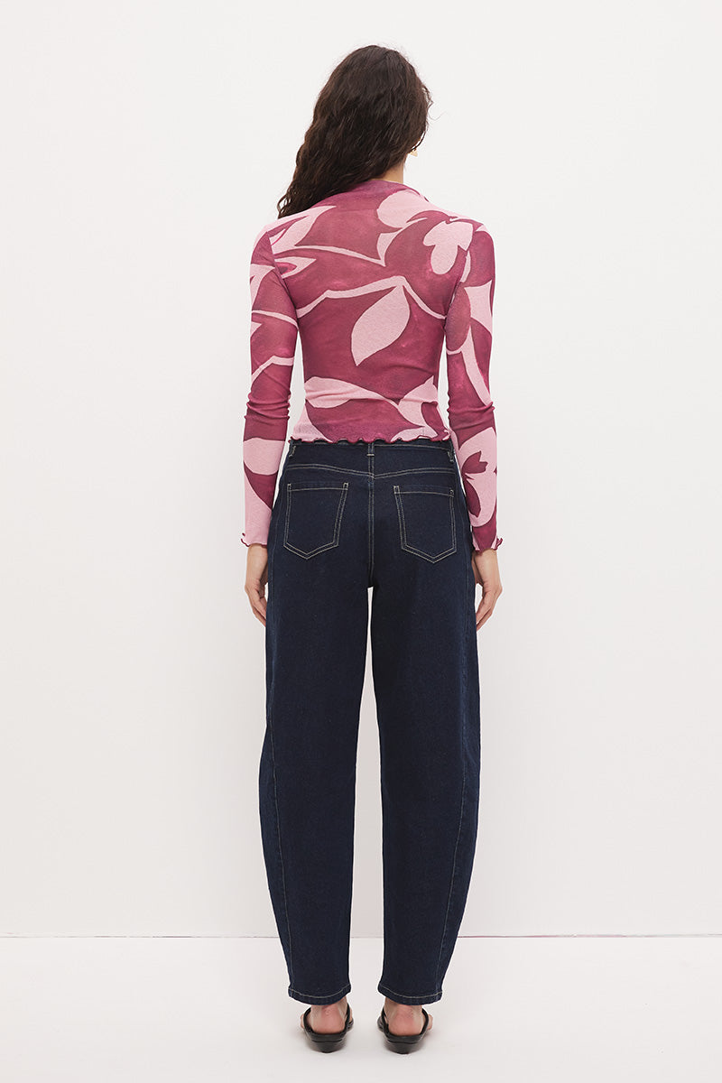 Woman wearing a semi-sheer long sleeve top in stretch ribbed mesh with an exclusive placement print, funnel neckline, centre front chest ruching, and lettuce hem finishes.