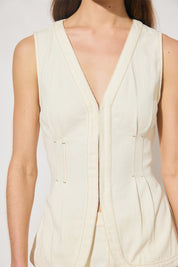 Sleeveless denim longline vest top with V neckline, pintucked waist, back tie, curved front hem, banded edges, and contrast topstitching