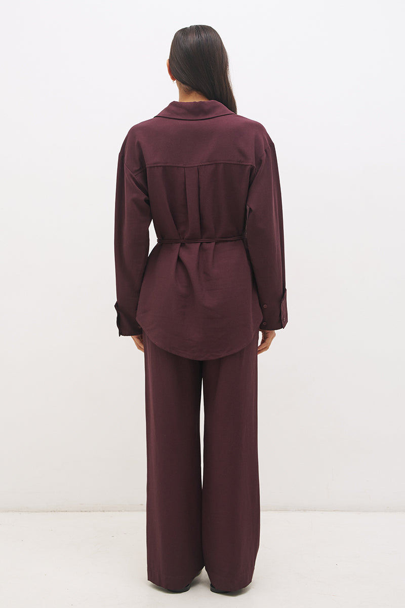 Woman wearing a satin-backed linen blend longline tunic with V neckline, curved hem, relaxed fit, and removable waist tie