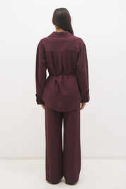 Woman wearing a satin-backed linen blend longline tunic with V neckline, curved hem, relaxed fit, and removable waist tie