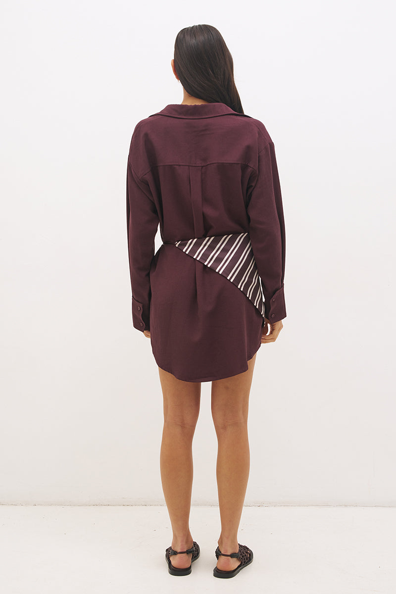 Woman wearing a satin-backed linen blend shirt dress with relaxed fit, collar neckline, curved hem, long sleeves, and removable scarf waist tie