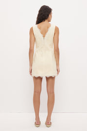 Sleeveless denim mini dress with V-neckline and scallop lace trim detail