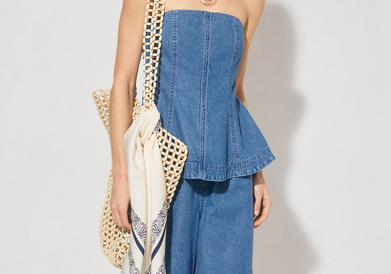 Strapless denim fit-and-flare top with cornelli piping, princess seams, flared circle-cut hem, and centre-back zipper