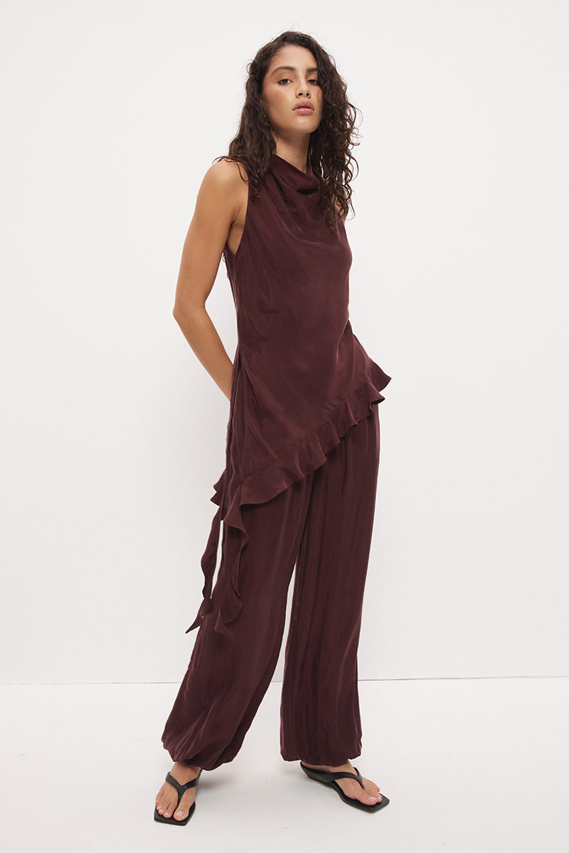 Sleeveless longline top in brushed cupro satin with narrow cowl neckline and asymmetric spiral flounce hem