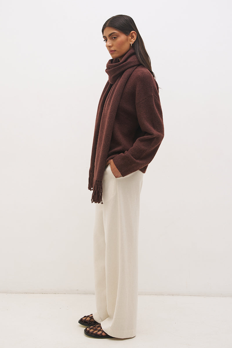 Woman wearing oversized scarf knit jumper with removable tassel scarf, crew neckline, ribbed trims, and relaxed silhouette