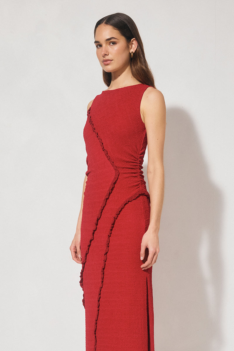 Sleeveless midi dress in textured jersey with skimming column silhouette, boat neckline, waist gathering, contrast frill panel detailing, and side seam split